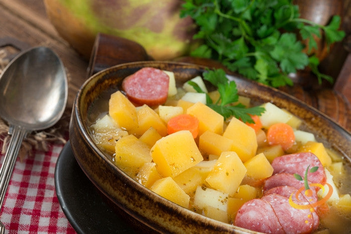 Bowl of rutabaga stew with American Purple Top rutabaga cubes, sausage, and vegetables with fresh herbs